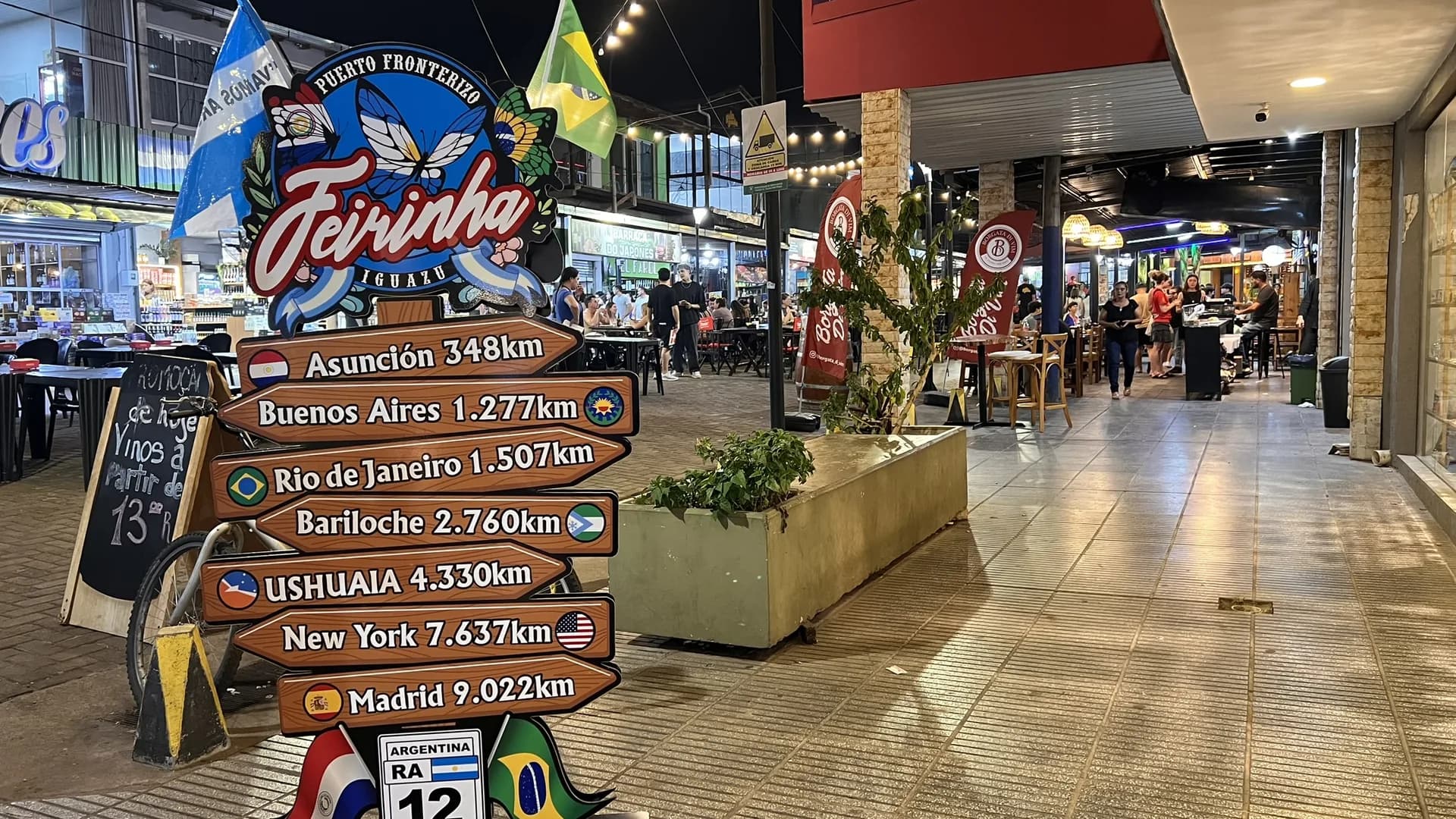 City Tour em Puerto Iguazú — feirinha de artesanato com cores vibrantes e movimento urbano