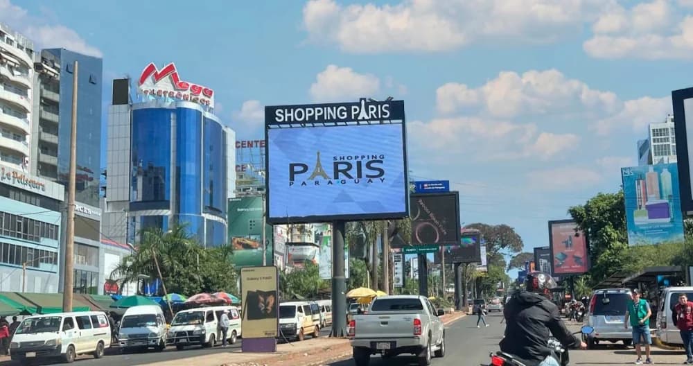 Avenida do microcentro de Ciudad del Este com Shopping Paris ao fundo — destino do passeio de compras no Paraguai saindo de Foz do Iguaçu