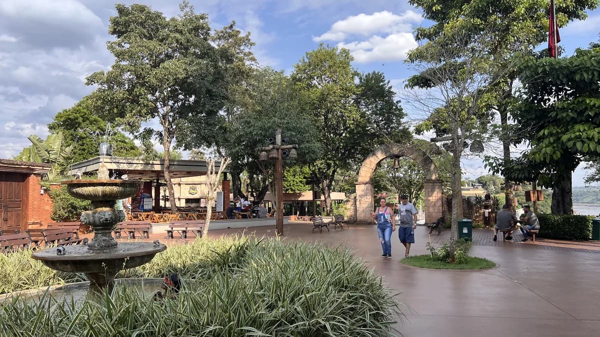 Vista ampla da praça do Marco das Três Fronteiras em Foz do Iguaçu, com arcos históricos, chafariz e área de convivência
