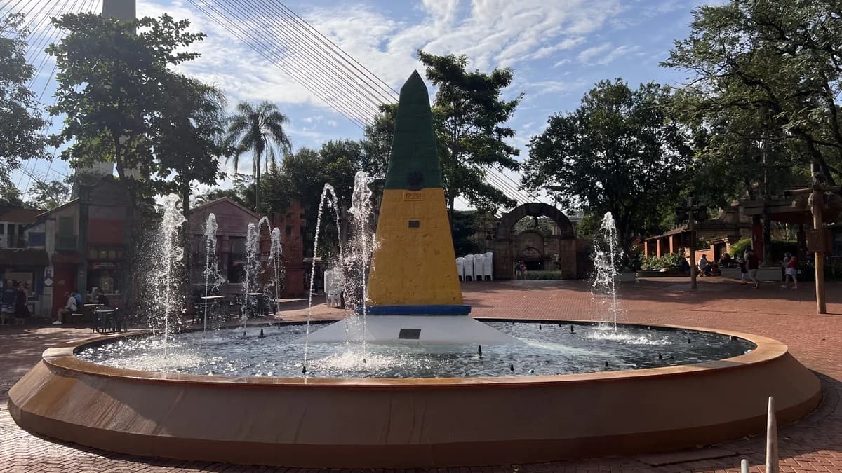 Obelisco brasileiro verde-amarelo do Marco das Três Fronteiras em Foz do Iguaçu, inaugurado em 20 de julho de 1903, com chafariz central e céu azul