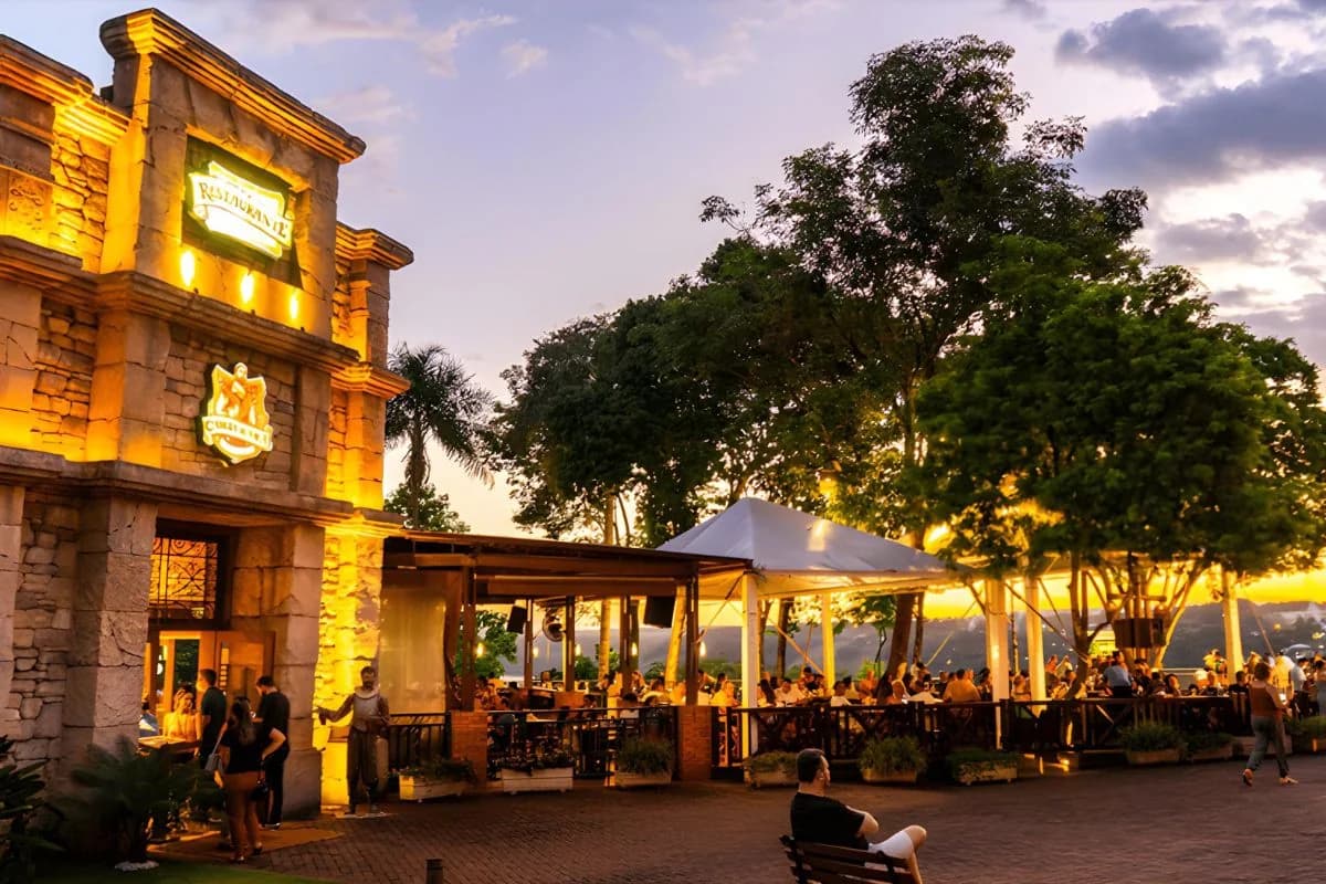 Fachada e área externa do Restaurante Cabeza de Vaca no Marco das Três Fronteiras em Foz do Iguaçu, com visitantes jantando ao entardecer — Foto: Marco das Três Fronteiras / Grupo Cataratas