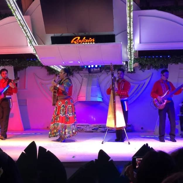 Músicos do Iporã Lenda Show tocando harpa paraguaia ao vivo no palco do Rafain Churrascaria Show