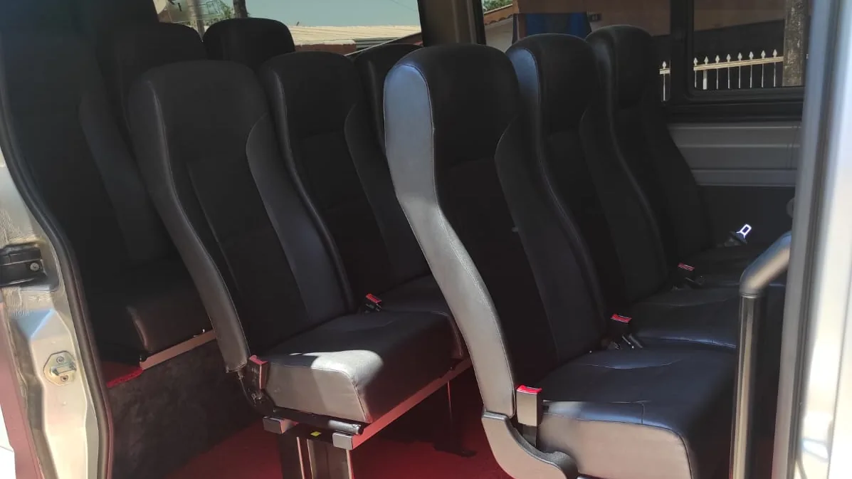 Porta lateral aberta da van Sprinter com estribo e poltronas individuais — aluguel de van com motorista em Foz do Iguaçu