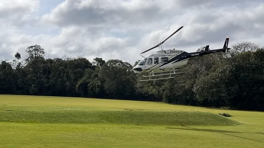 Helicóptero de Helisul despegando del césped del helipuerto frente al Parque Nacional do Iguaçu